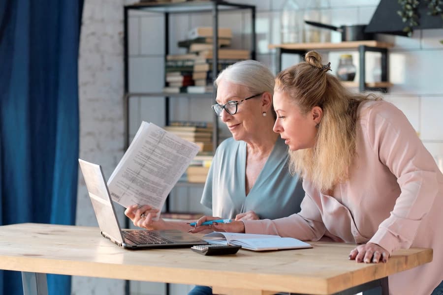 CareVicinity support worker helping older woman review care documents at home